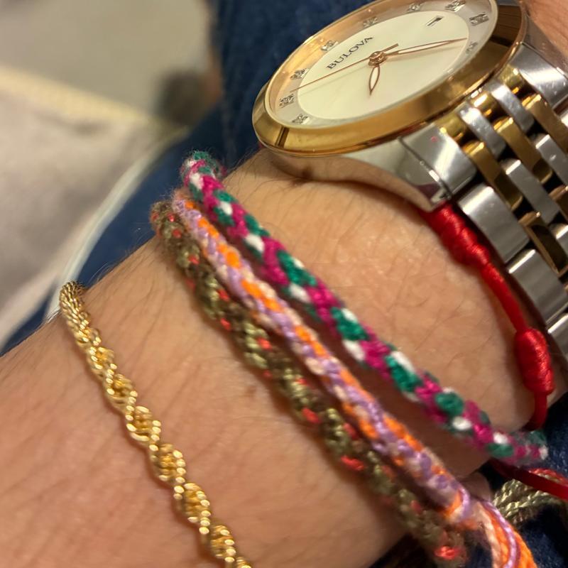 Três pulseiras da Linhas de Sol empilhadas no pulso de uma cliente