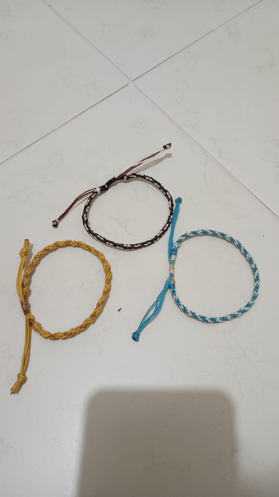 Três pulseiras trançadas com diferentes cores